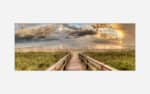 A panoramic art print of a serene beach scene with a wooden path leading to the ocean, featuring lush beach grass, a cloudy sky, and a warm sunset glow.