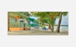 A vibrant painting of colorful beachfront cabins with palm trees on a sandy tropical beach.