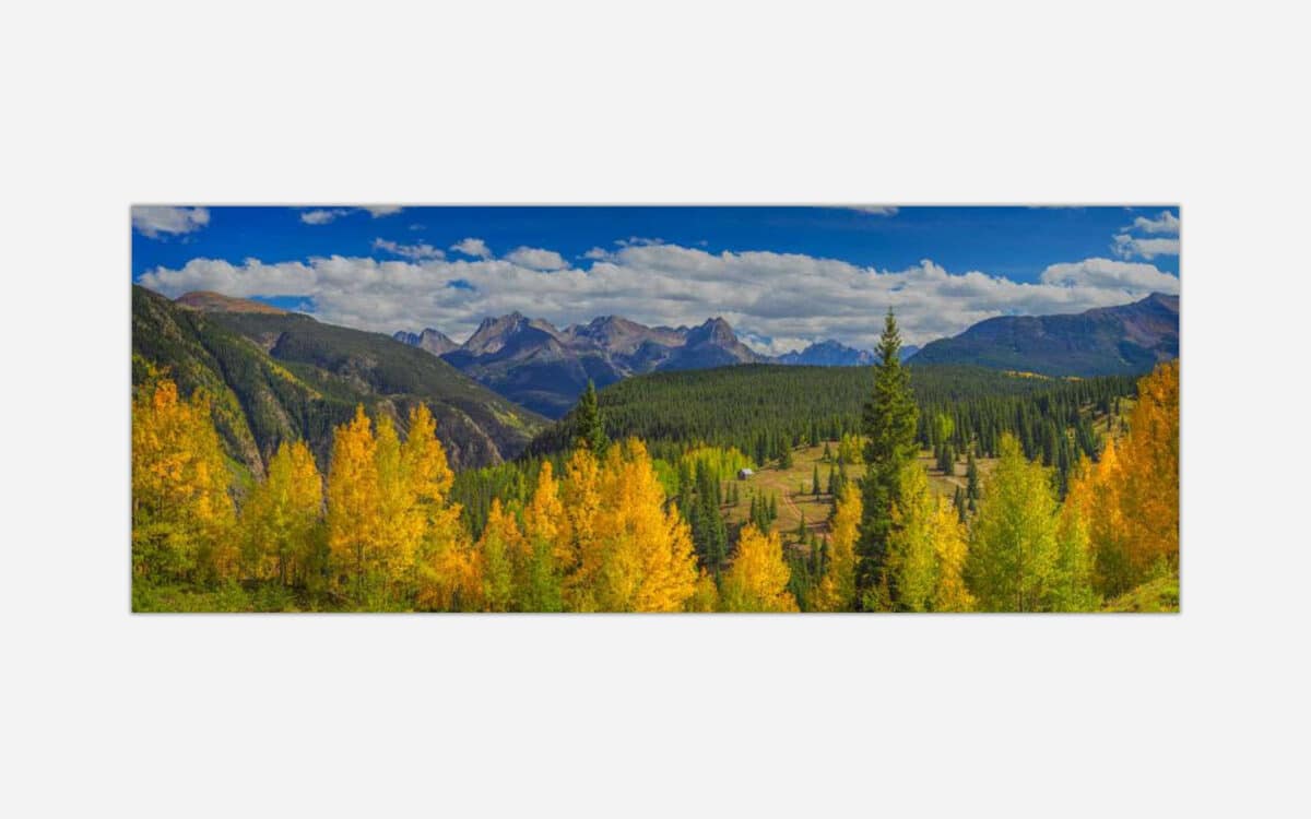 Panoramic image of mountains and autumn colored trees in a vibrant landscape