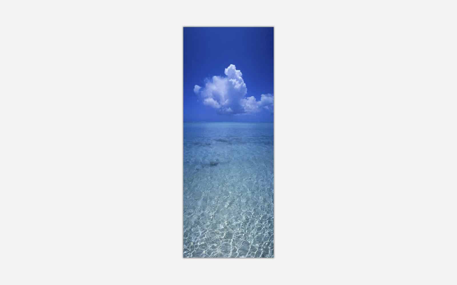 Crystal Blue A vertical panoramic image of clear blue ocean water with a detailed cloud formation in the sky above