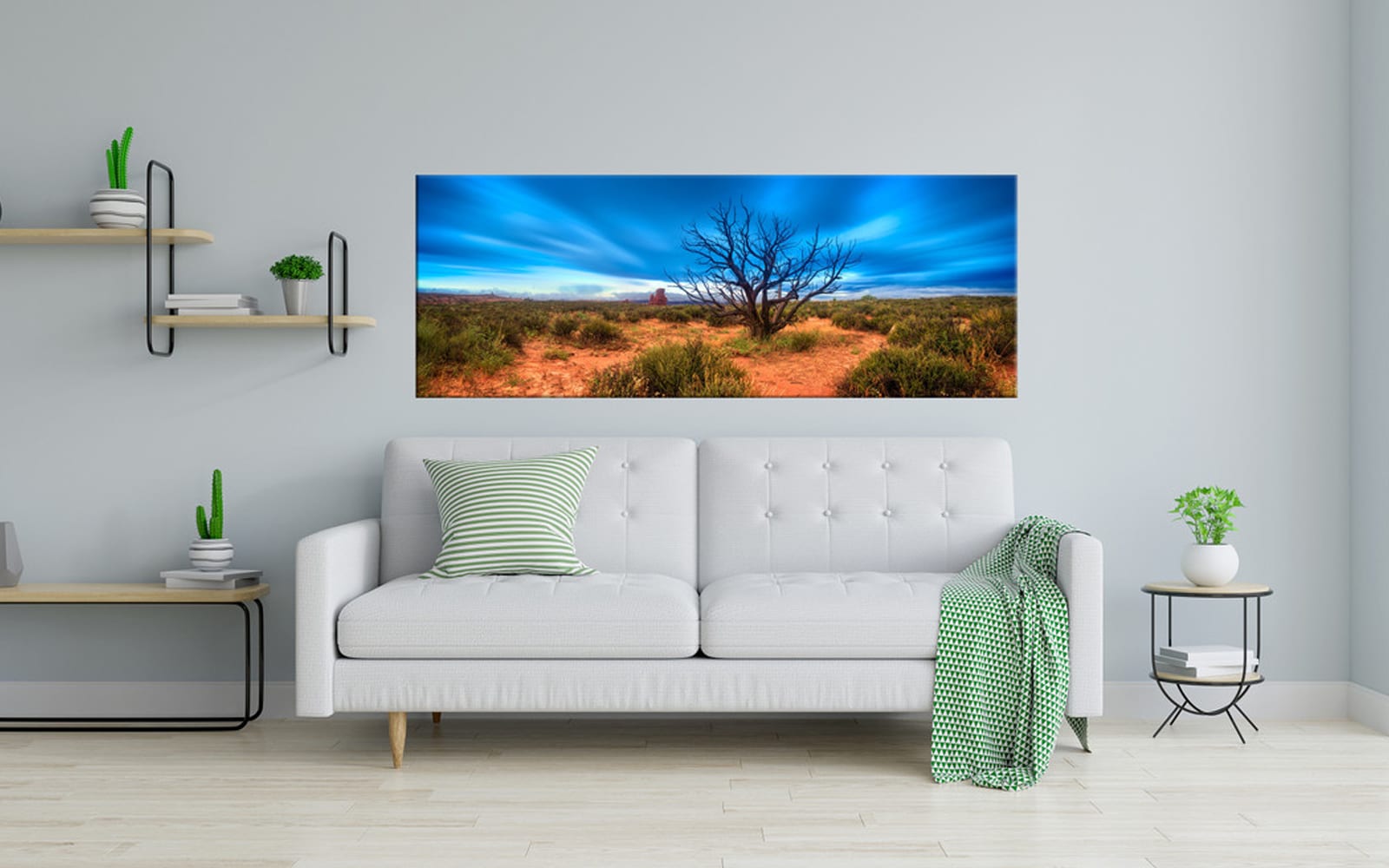 Desert Spirit (5) A panoramic landscape canvas depicting a vibrant blue sky and red desert, mounted above a white sofa in a modern living room setup.