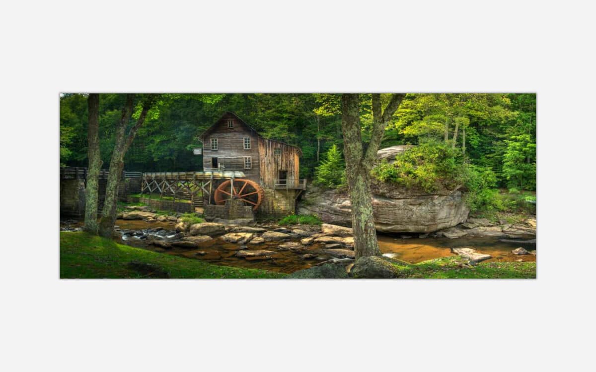 A serene landscape painting featuring a rustic mill with a waterwheel beside a gentle river, surrounded by lush forest and rocky terrain.
