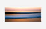 A blurred image of a beach scene at sunset with pastel colors and a tranquil ocean, creating an abstract seascape suitable for modern wall decor.