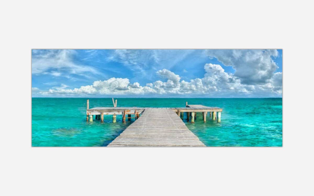 A vibrant art piece featuring a wooden pier extending into the turquoise waters of a tropical ocean with fluffy clouds in the sky.