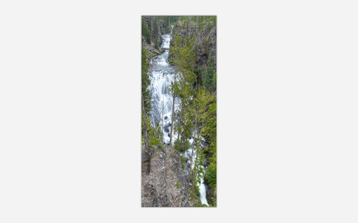 Aerial photograph of a cascading waterfall amidst green forest trees suitable for wall art.