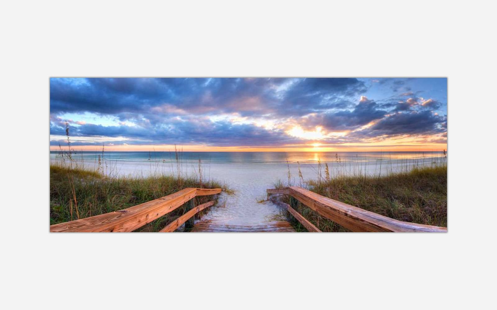 Life a Beach (1) A canvas print of a tranquil beach scene at sunset with a wooden pathway leading through dunes to the shore, with vibrant colors in the sky and reflections on the water.