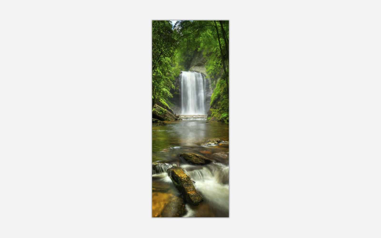 Looking Glass Falls A photographic art piece of a serene waterfall cascading into a calm river surrounded by lush greenery.