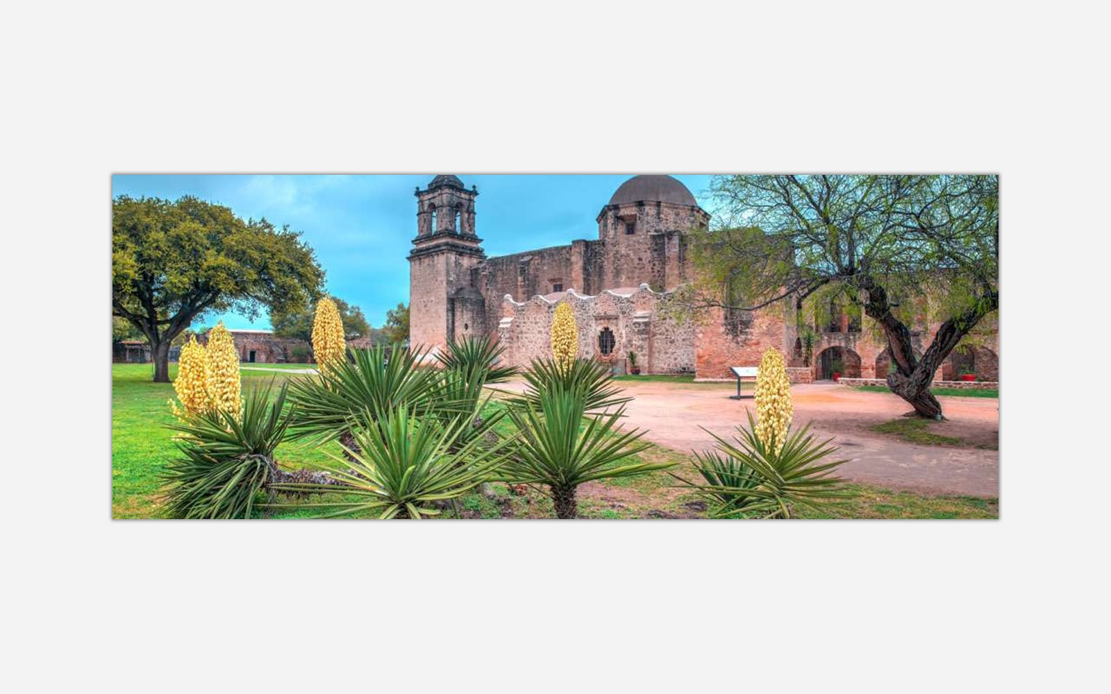 Mission San Jose (1) Alt text: Panoramic view of a historic mission with Spanish architectural elements, surrounded by yucca plants and trees in San Antonio, Texas.