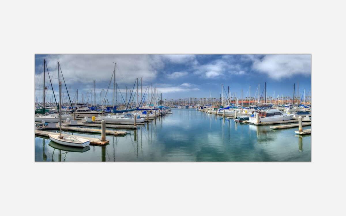 A painting of a serene marina with multiple docked boats under a cloudy blue sky.